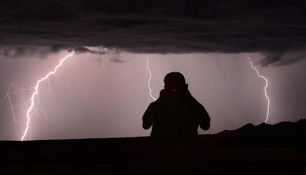 Силуэт фотографа-охотника за бурями Mike Meadows на фоне молний