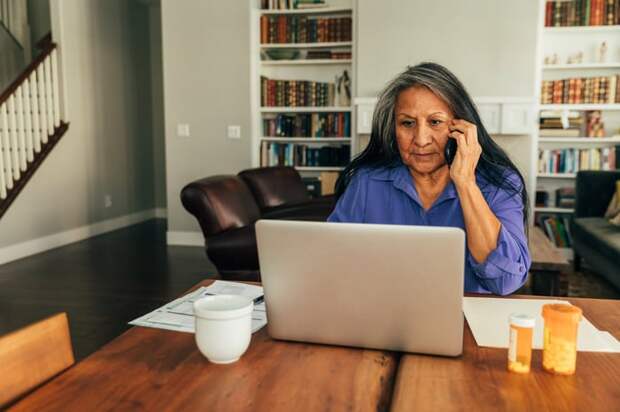 Person looking at laptop and talking on phone.