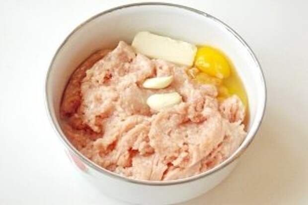 Куриный фарш взбить блендером со сливочным маслом, яйцом и чесноком.