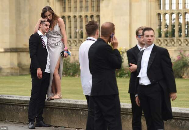 One exhausted party-goer leans on a male friend's head for support after celebrating until the early hours of Tuesday morning