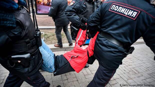 Полицейские несут в автозак участника акции протеста в Москве