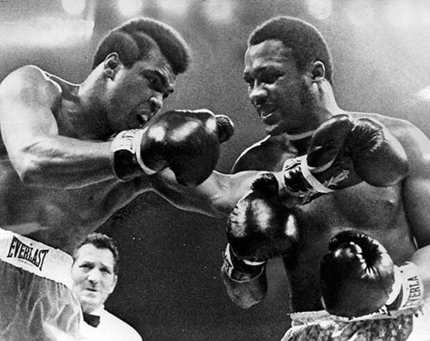 Joe Frazier, right, appears to be smiling as challeger Muhammad Ali misses with a left in the title fight. (March 1971)