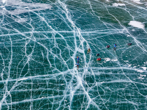lake Baikal, Russia. Baikal in winter becomes the biggest ice rink in the world, fully covered with small and huge cracks, resembling spider's web. We enjoyed more than 300 kilometers of smooth (and sometimes rough) ice, skating from Listvyanka to Khuzhir whithin less than two weeks. On the photo you can see small figures of skaters dragging loaded sledges behind.