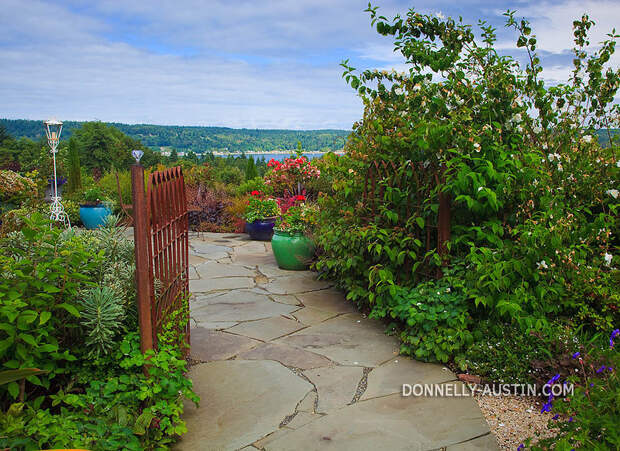 Vashon-Maury Island, WA<br /> Driscoll garden, flagstone pathway to a patio with a view of Quartermaster Harbor