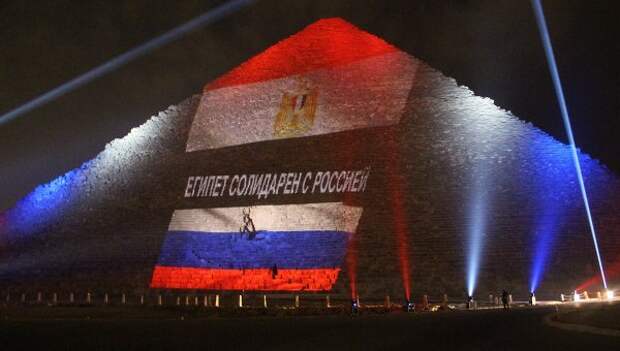 Древнеегипетская пирамида Хеопса на плато Гиза в Каире, подсвеченная цветами российского и египетского флагов во время акции памяти жертв