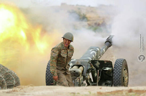 Военнослужащий стреляет из артиллерийского орудия во время боя с азербайджанскими силами в Нагорном Карабахе