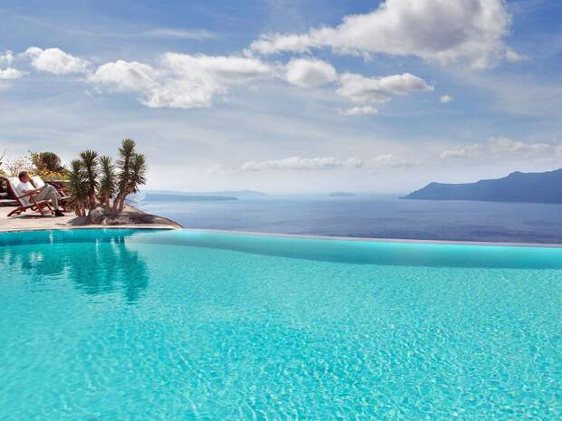 the-perivolas-hotel-in-greece-has-the-one-of-the-most-beautiful-infinity-pools-with-blue-water-that-seems-to-spill-out-right-into-the-mediterranean