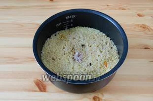 Когда рис впитает практически всю воду, добавляем в плов головку чеснока, предварительно сняв с неё верхнюю шелуху. Утапливаем чеснок в рис, закрываем крышку и доводим плов до готовности риса.