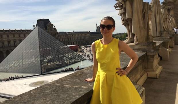 Girl in yellow dress posing in front of the Louvre, Paris