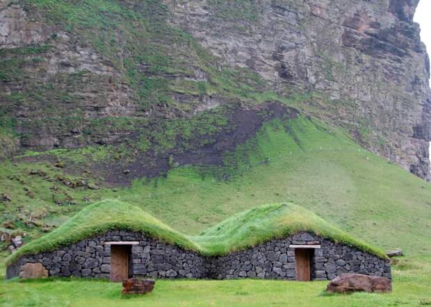 Дома с дерном на крыше на острове Хаймаей, Исландия. Дерновые крыши первоначально начали делать в Исландии из-за отсутствия природных ресурсов. Люди использовали местные строительные материалы, какие им были доступны. зелёные крыши, экологичный дом