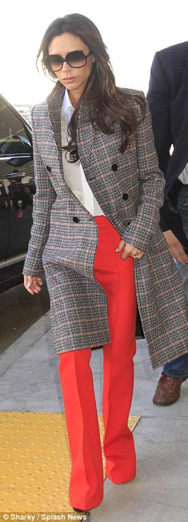 Preppy touch: The fashion designer donned a preppy plaid coat over her head-turning attire
