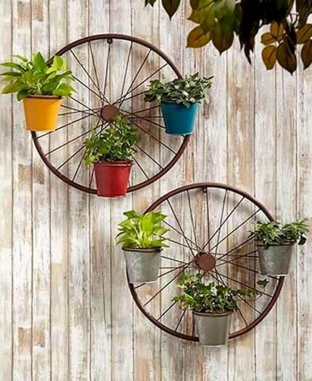 Колеса от велосипеда с кашпо на стене