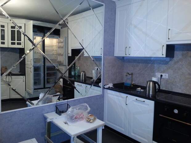 Белая просторная кухня, фасеточное зеркало на стене