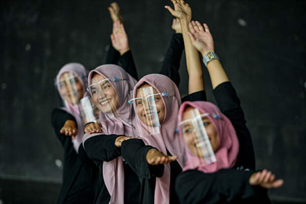 Девушки танцуют в защитных масках для лица во время тренировки в художественном и культурном центре в Банда-Ачехе, Индонезия