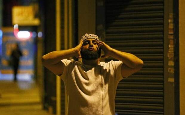 Человек молится после того, как автомобиль столкнулся с пешеходами возле мечети в Финсбери-парк на севере Лондона