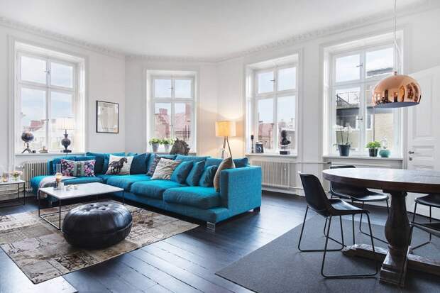 Скандинавский интерьер с синим диваном и антикварной печью