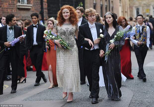 It all started so well: Cambridge revellers make their way to the ball holding bouquets of flowers on Monday evening