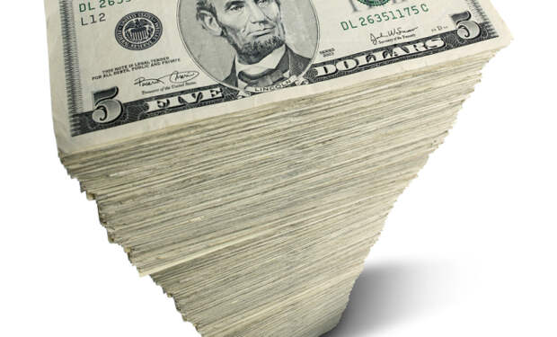 Stack of five-dollar bills on white background