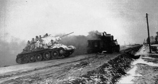14. Cоветский танк Т-34 с десантом пересекает магистраль Житомир-Бердичев. На дороге выгорает танк Pz.Kpfw. VI «Тигр». 1-й Украинский фронт, январь 1944-го года ВОВ 1941-1945, вмв, война