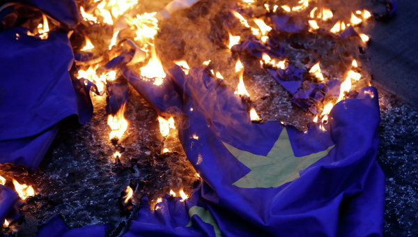 Демонстранцы жгут флаг на акции протеста против принятия проекта соглашения ЕС в Афинах. Архивное фото Демонстранцы жгут флаг на акции протеста против принятия проекта соглашения ЕС в Афинах. Архивное фото