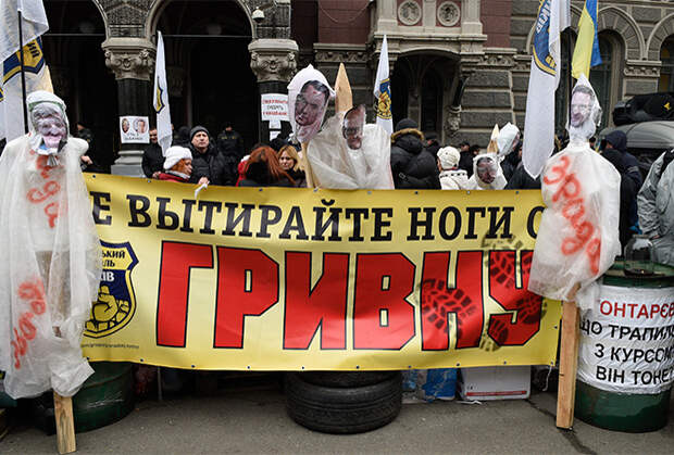 Участники акции протеста с плакатом «Не вытирайте ноги о гривну». Киев, февраль 2015 года