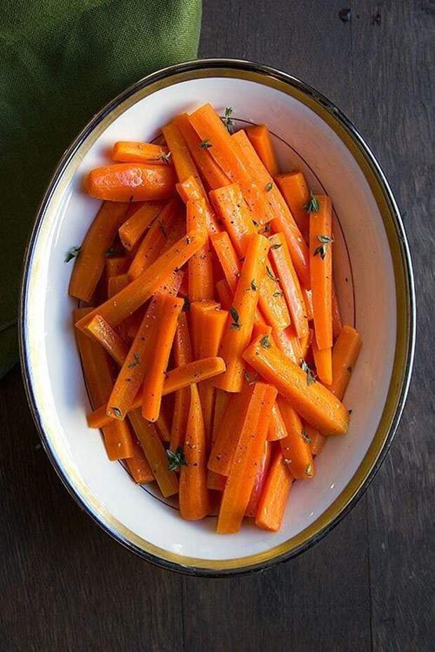 Порежьте морковь на длинные брусочки, растопите масло в большой тяжелой сковороде, добавьте морковь, накройте крышкой и тушите в течение 20-30 минут. Затем прибавьте огонь, налейте в сковороду кленовый сироп или жидкий мёд и сок выжатого лимона. Жарьте ещё 2 минуты.