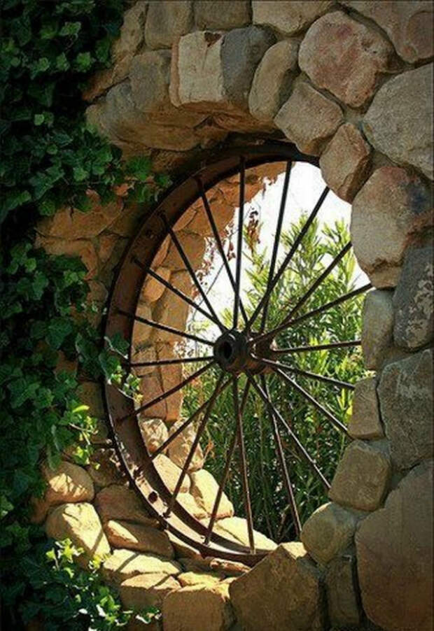 Окно в сад из старого колеса от телеги.