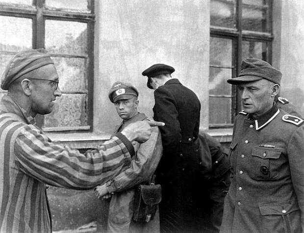 Освобожденный узник указывает на нацистского охранника, который жестоко издевался над заключенными в концентрационном лагере Бухенвальд. 1945 20 век, история, фотографии