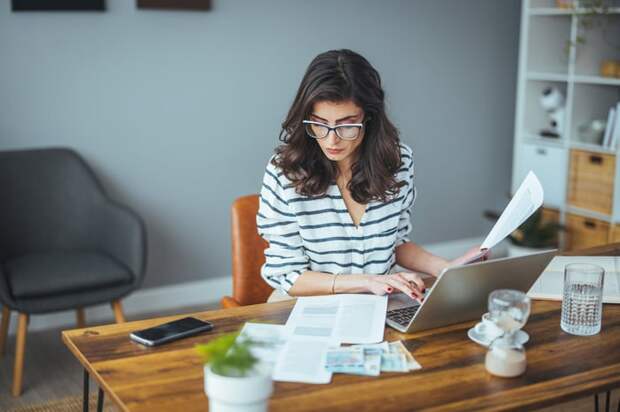 A person at a desk with a laptop and documents.