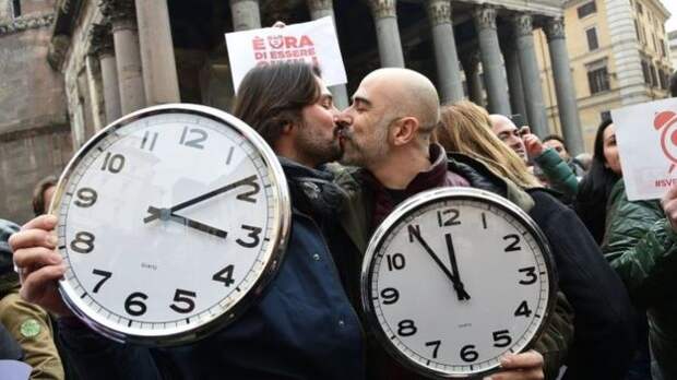 A couple holding alarm clocks kiss in Rome. Photo: 23 January 2016