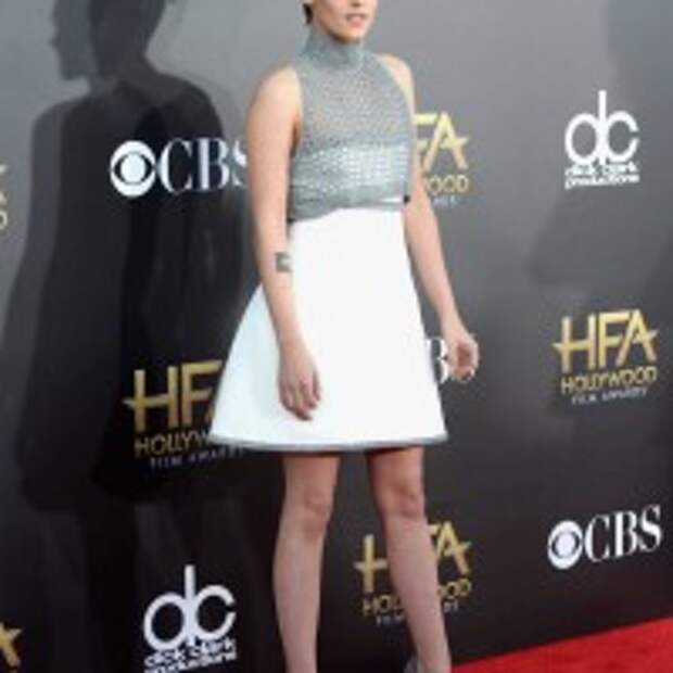 Kristen Stewart flared white skirt rising up gray crop top with pair of Casadei shoes