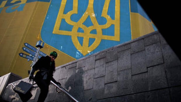 Женщина проходит мимо огромного украинского флага. Архивное фото