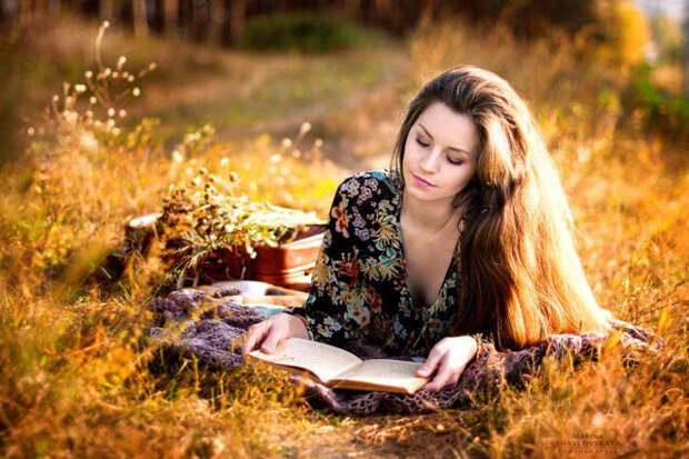 девушка лежит с книгой в траве