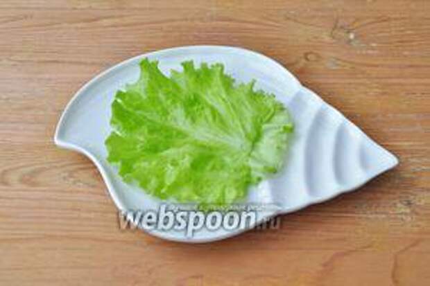 На порционную тарелку положить лист салата.