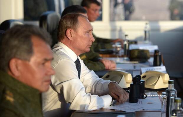 Министр обороны РФ Сергей Шойгу и президент РФ Владимир Путин (слева направо) наблюдают за ходом стратегических командно-штабных учений российской армии "Центр-2015" на полигоне "Донгузский"