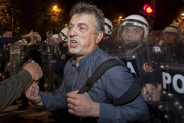 Riot policemen push demonstrators while attempting to disperse them outside the parliament building in the capital Podgorica, Montenegro, October 17, 2015. Montenegro's police used teargas on Saturday to disperse hundreds of anti-government protesters outside the parliament building in the capital Podgorica and local media said several people had suffered light injuries. The ex-Yugoslav republic's main opposition bloc, the Democratic Front, set up tents in front of the parliament 20 days ago demanding the resignation of veteran Prime Minister Milo Djukanovic and the formation of an interim government pending fresh elections.   