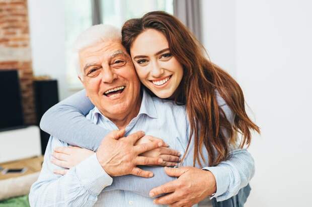 Two smiling people with arms around each other.