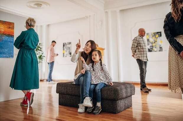 Woman and daughter looking at art in a museum.