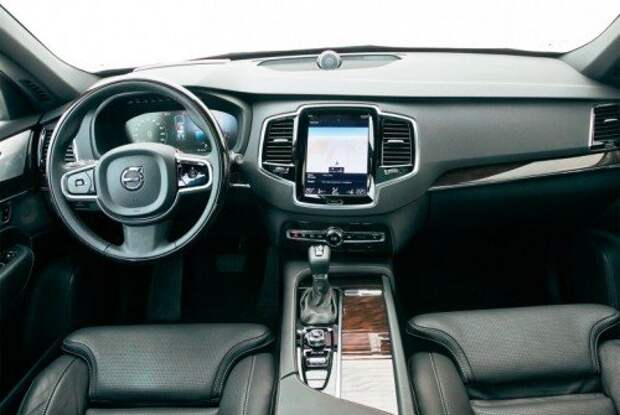 Интерьер нового XC90 выглядит дорого, но уровнем отделки все же уступает BMW. Почти все функции «зашиты» в 12 дюймовый планшет на консоли. Деревянный руль – без обогрева. Если боитесь замерзнуть, заказывайте кожаный.