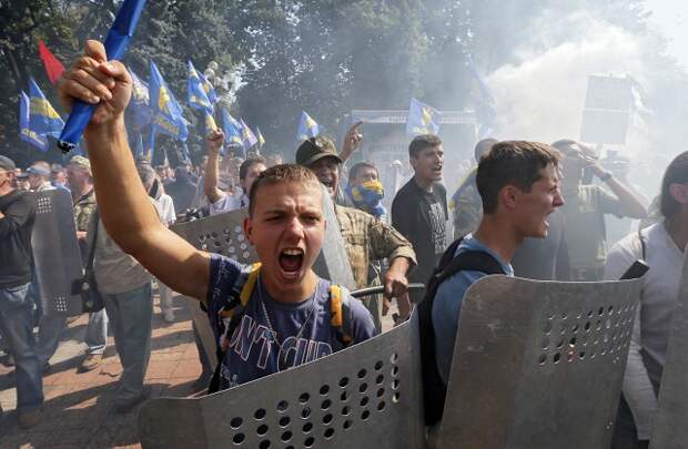 Столкновения с противниками этих поправок у здания парламента Украины не прекращаются уже несколько часов, в милиционеров летят дымовые шашки…