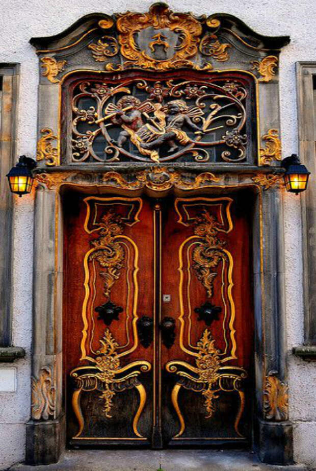 Массивная деревянная дверь, украшенная коваными элементами.