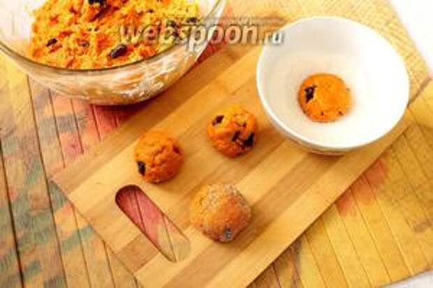 Отщипываем небольшие кусочки теста, у меня размером с грецкий орех. Раскатываем каждый кусочек в шар, слегка приплюснув его, обмакиваем одной стороной в сахар.