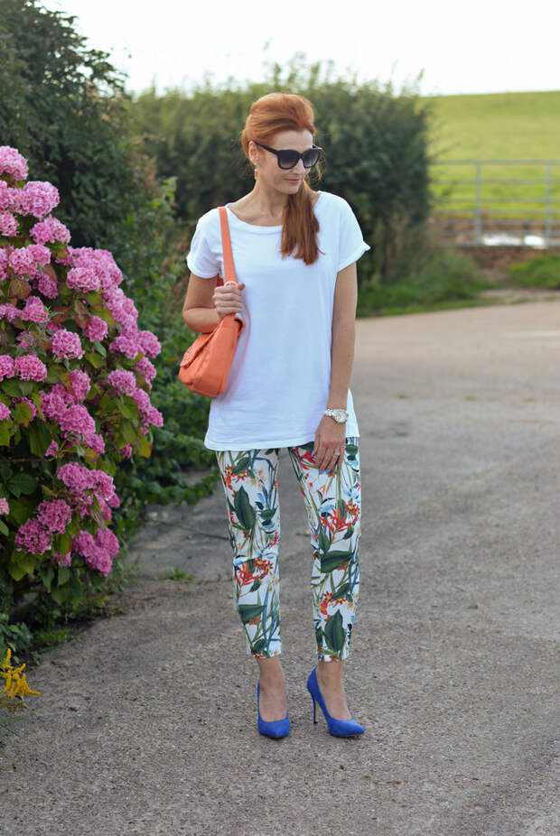 White boyfriend tee, tropical print trousers, cobalt heels, peach bag