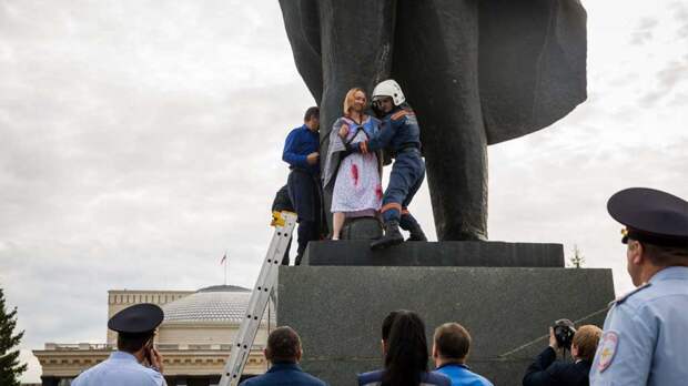 Новый День: ''Против нищеты и полицейского государства'': девушка с флагом России приковала себя к памятнику Ленину в Новосибирске