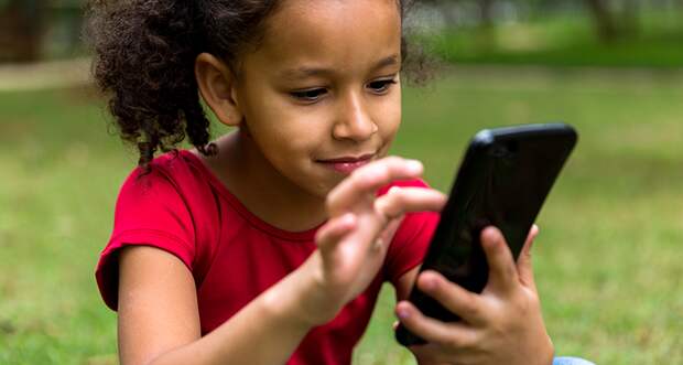 a girl using a smartphone while sitting outside