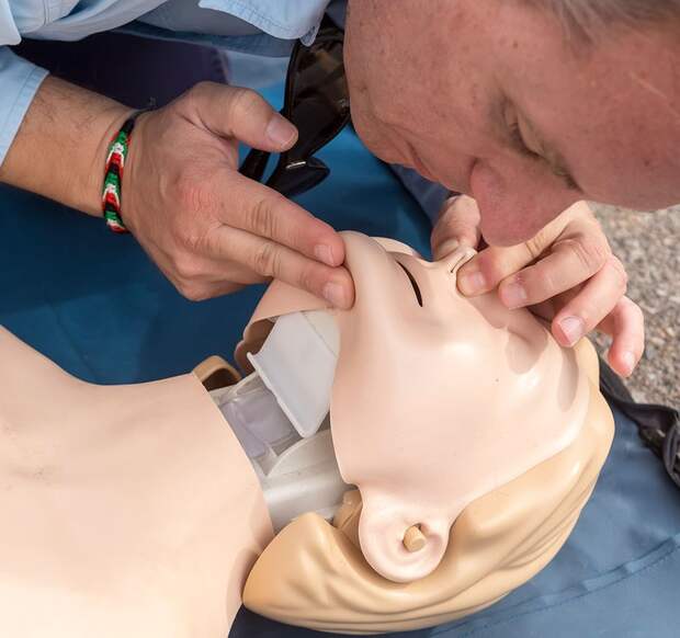 The instructor showing CPR on training doll