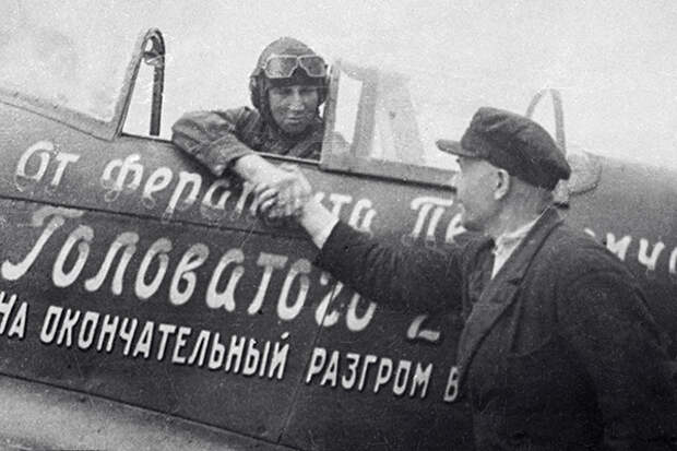 Ферапонт Головатый (справа) передает летчику Борису Еремину (слева) второй самолет