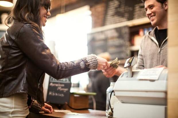 Woman paying for purchase with cash.
