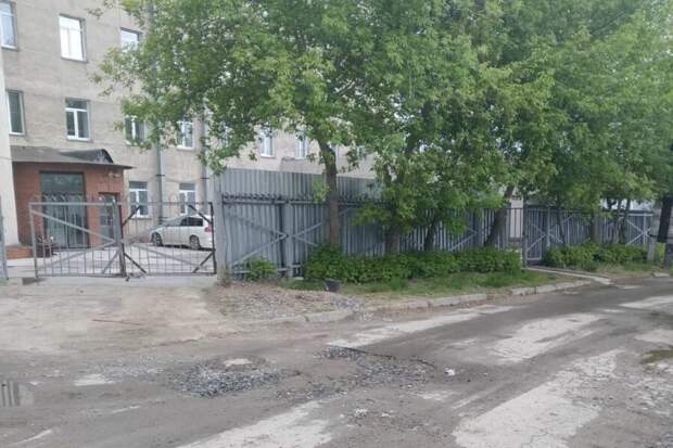 "И как нас это спасёт?": в Новосибирске возвели глухой забор вокруг пятиэтажки с мигрантами