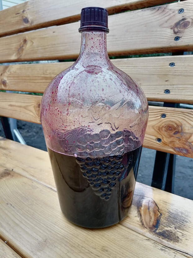 Готовая наливка из чёрной смородины в той же бутылке, где ягоды настаивались на водке. Фото автора